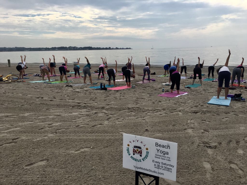 Group outdoor yoga class on a rooftop